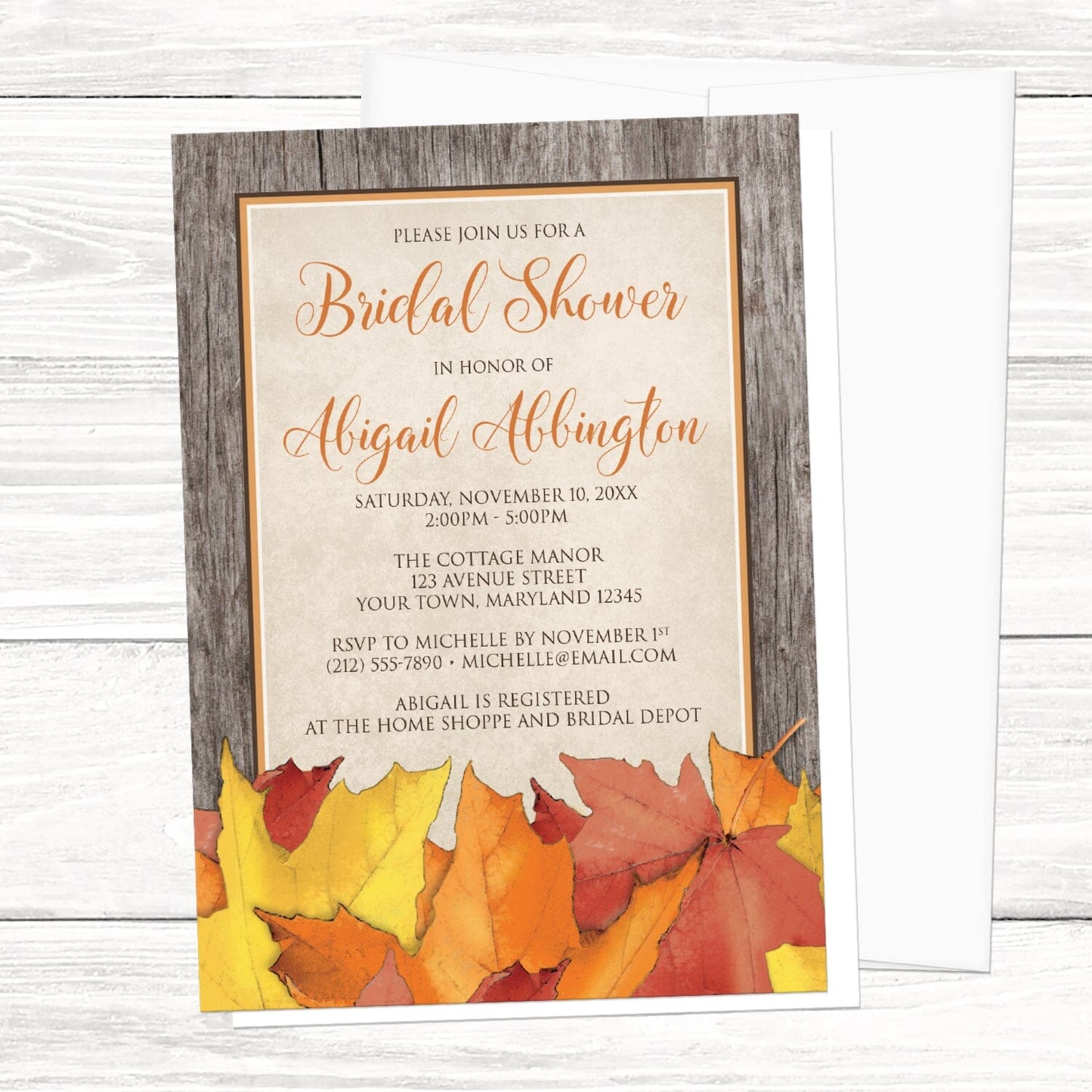 Rustic Wood and Leaves Fall Bridal Shower Invitation shown on a light wood surface with a white envelope.