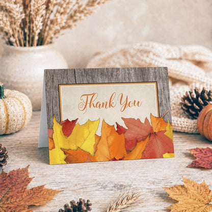 Rustic Wood and Leaves Fall Thank You Card on a tabletop with a vase, fall leaves, and autumn decor.