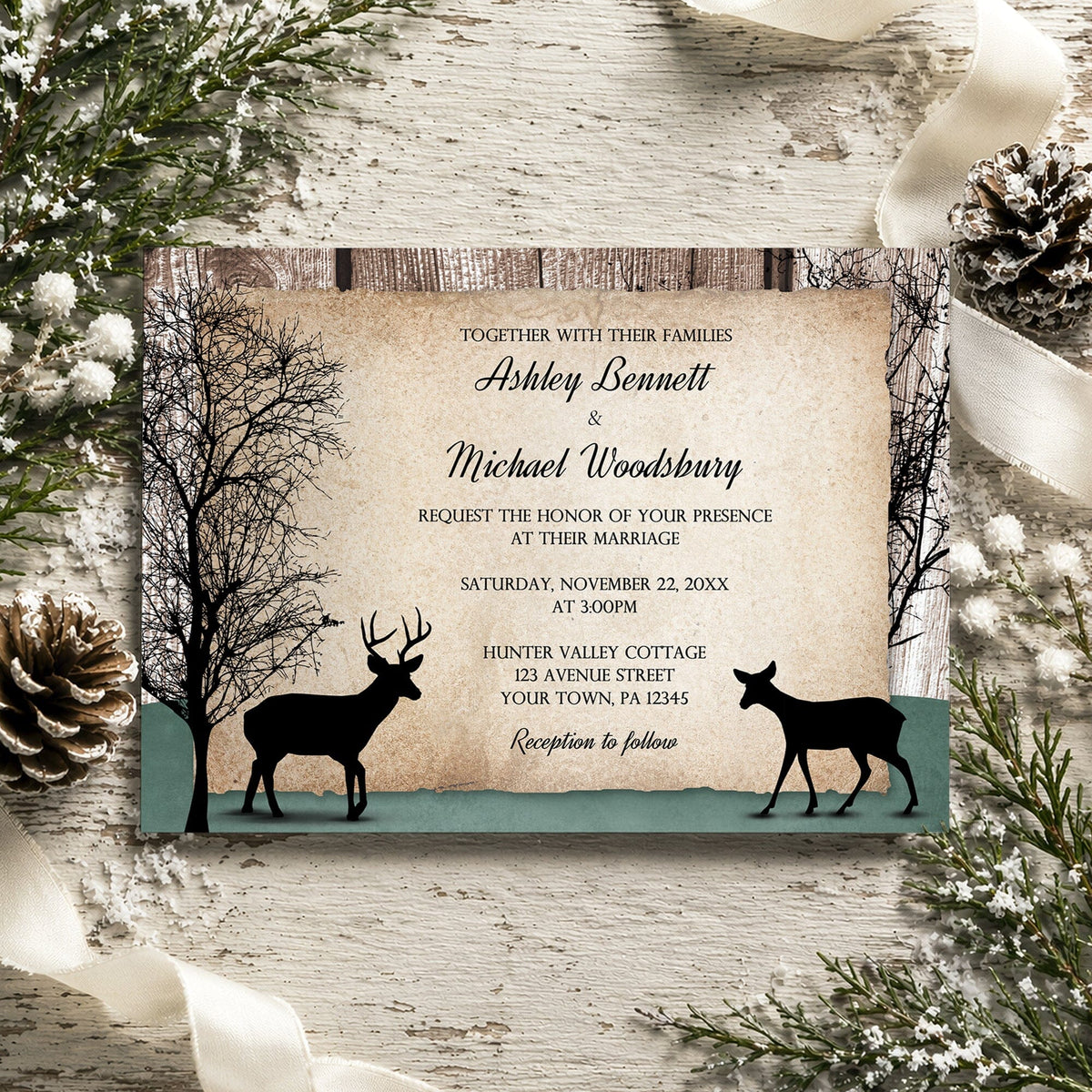 A rustic deer wedding invitation featuring black deer silhouettes, bare trees, and a hunter green ground, styled on a whitewashed wood surface with pinecones, ribbons,  and winter greenery.