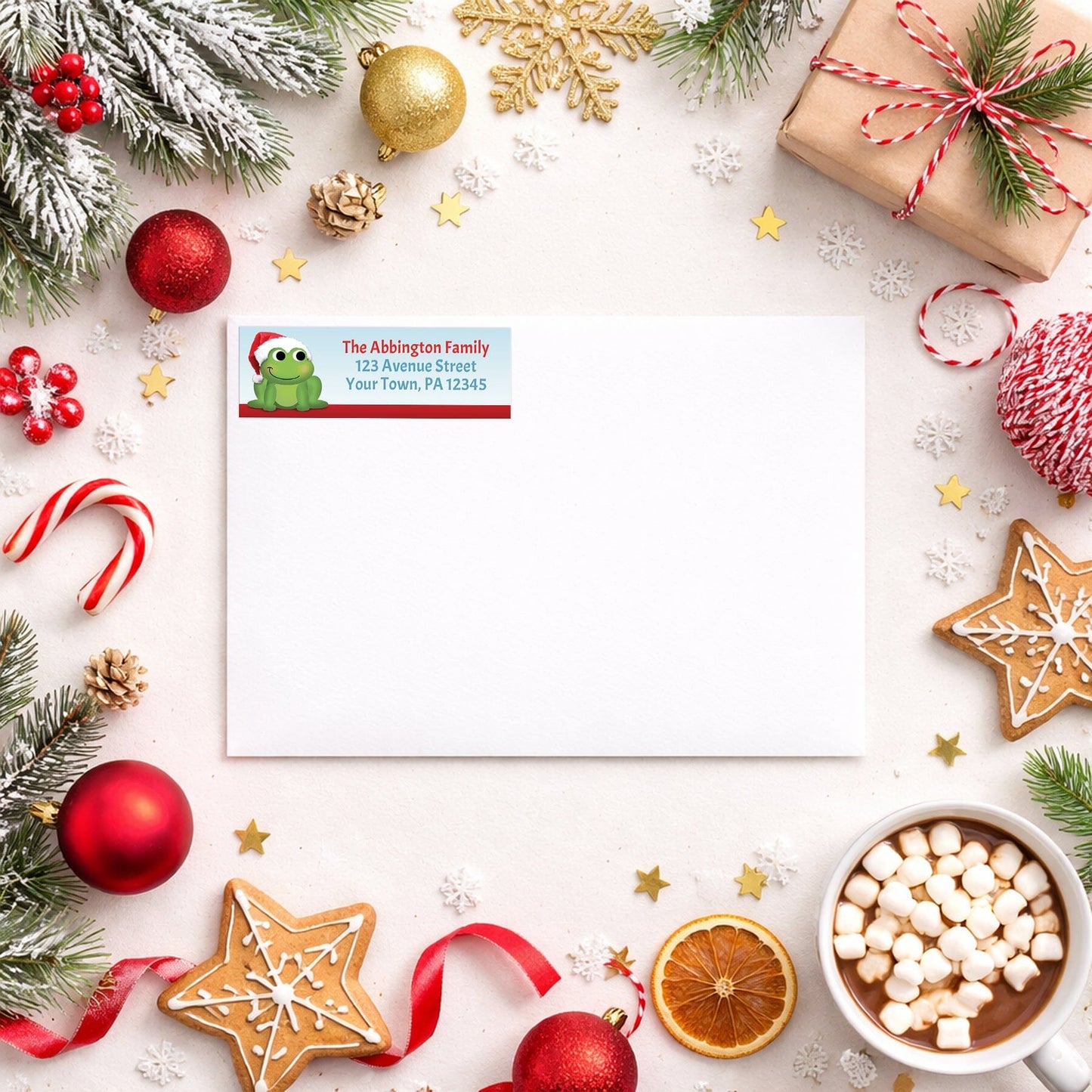 Santa Hat Frog Christmas Address Label shown on a white envelope with winter Christmas holiday supplies