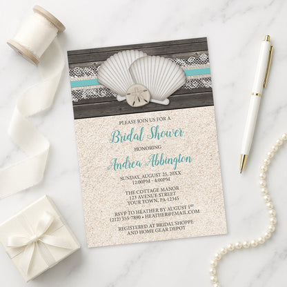 Beach-themed bridal shower invitation with shells, sand, and lace on a marble surface.