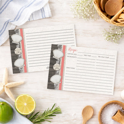 Set of Seashell Lace Wood and Sand Coral Beach Recipe Cards on a wooden surface with beach house kitchen items.