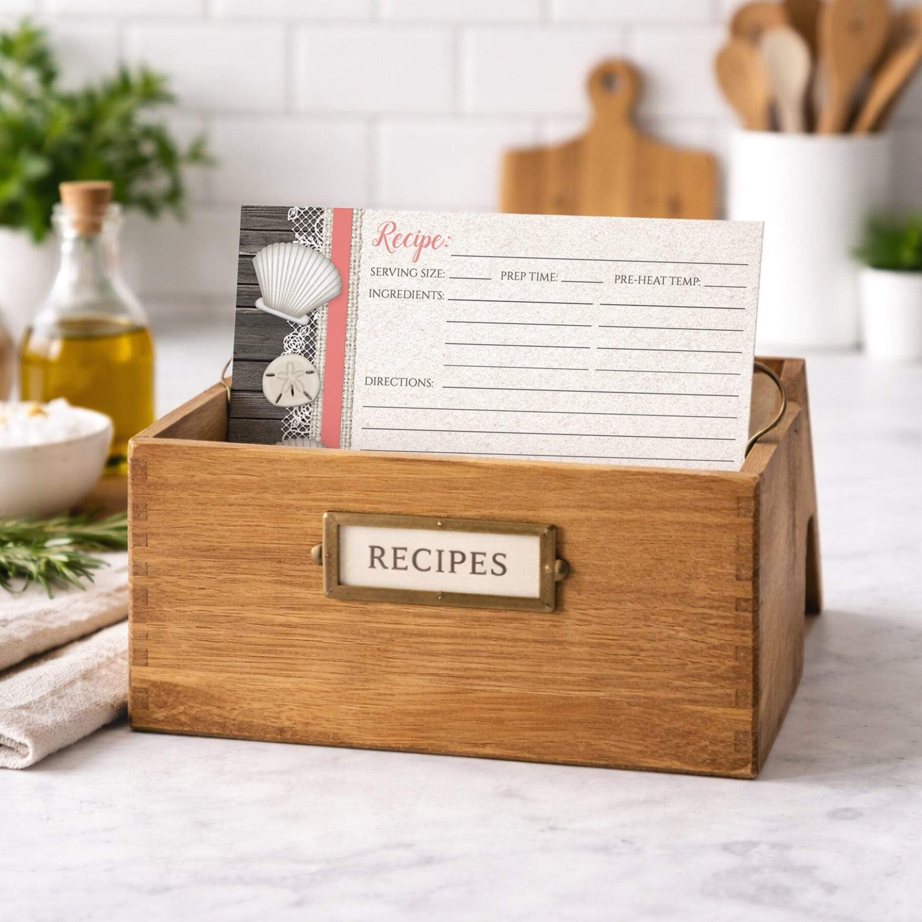 Wooden recipe box with a Seashell Lace Wood and Sand Coral Beach Recipe Card on a kitchen counter.