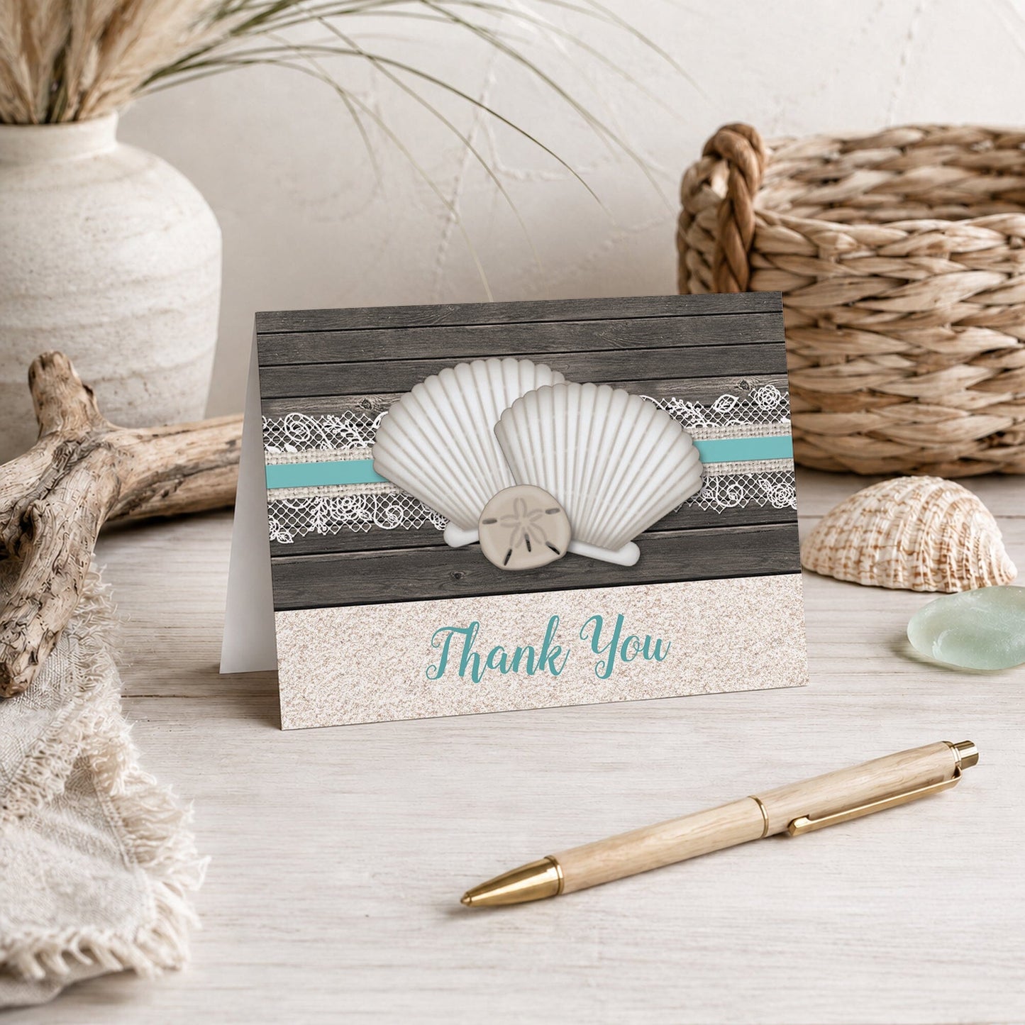 Seashell Lace Wood and Sand Teal Beach Thank You Card shown on a beach house tabletop with coastal decor and a pen.