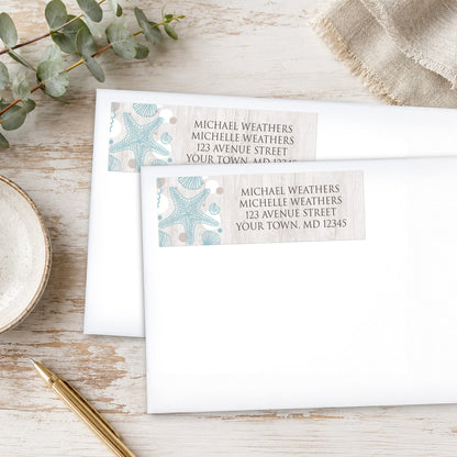 Seashell Whitewashed Wood Beach Address Labels, shown on white envelopes, on a wooden surface with eucalyptus leaves and a pen.