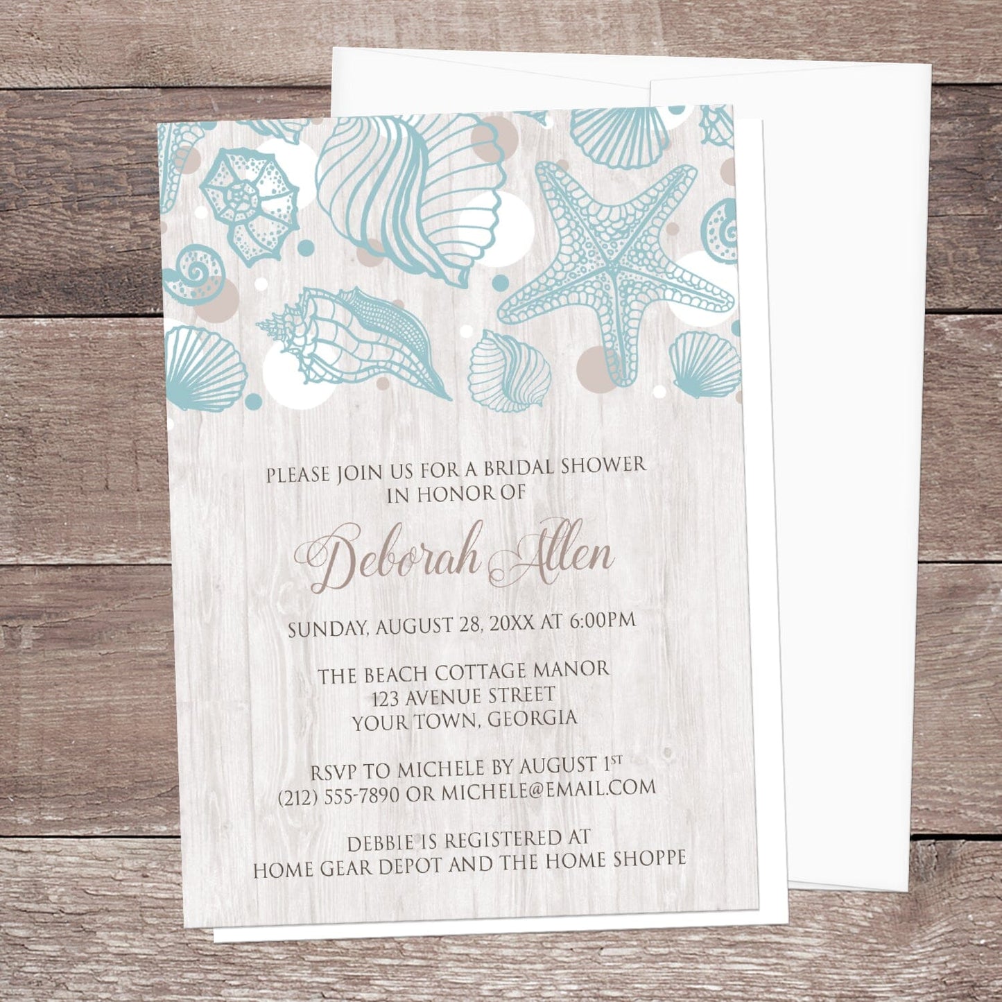 Seashell Whitewashed Wood Beach Bridal Shower Invitation shown on a rustic wood surface with a white envelope.