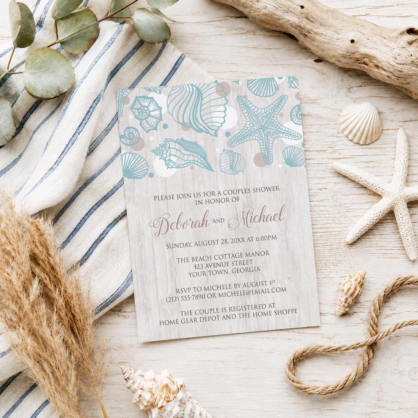Seashell Whitewashed Wood Beach Couples Shower Invitation shown on a light wooden surface with seashells and coastal decor.