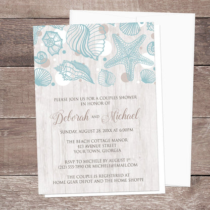 Seashell Whitewashed Wood Beach Couples Shower Invitation shown on a brown wood surface with a white envelope.