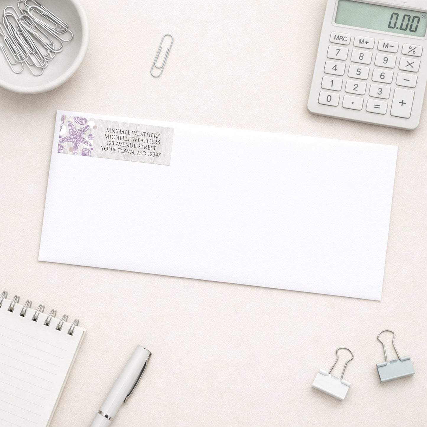 Seashell Whitewashed Wood Purple Beach Address Label shown on a white envelope with office supplies