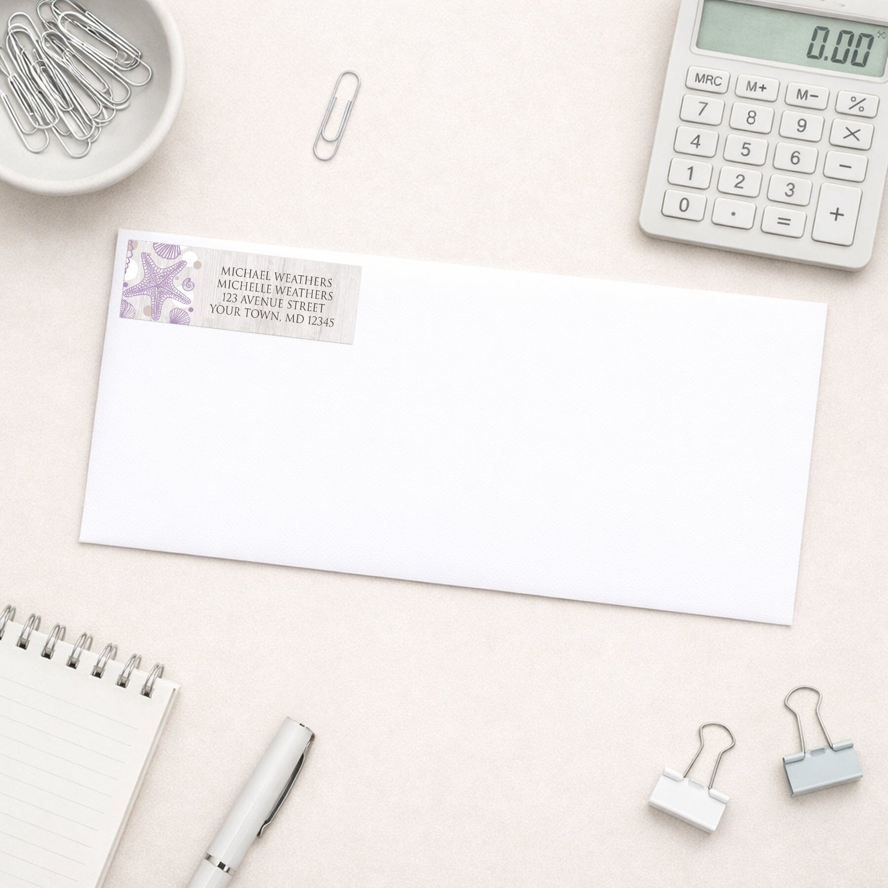 Seashell Whitewashed Wood Purple Beach Address Label shown on a white envelope with office supplies