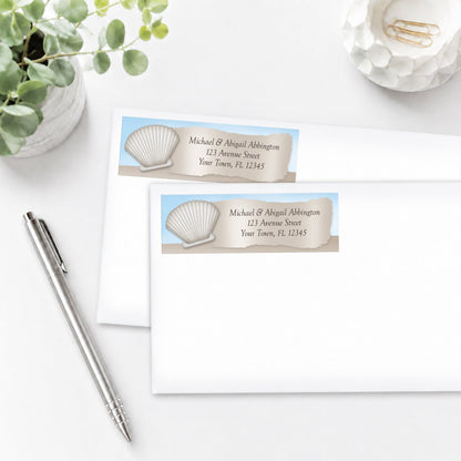 Seashell in the Sand Beach Address Labels on white envelopes, shown on a white surface with a pen and plant.