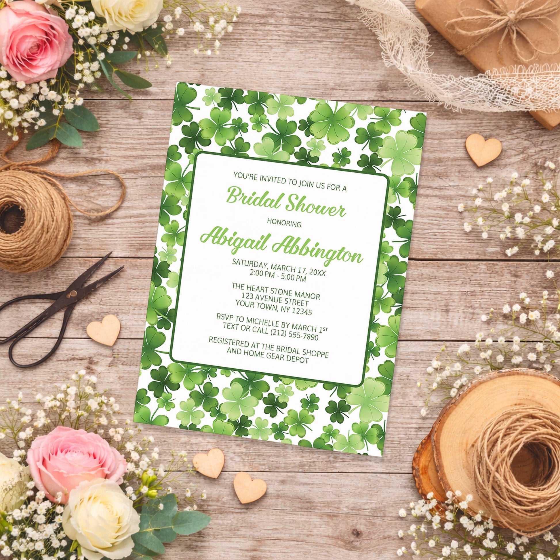 Shamrocks and 4-Leaf Clovers Bridal Shower Invitation on a wooden surface with flowers and twine.