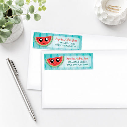 Smiling Watermelon Slice Address Labels, shown on white envelopes, on a white surface with a pen and plant.