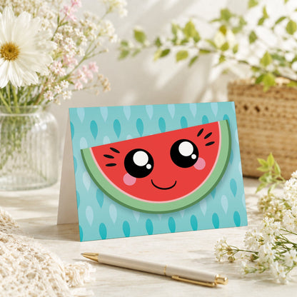 Smiling Watermelon Slice Note Card shown on a tabletop with a vase, spring and summer flowers, and a pen.