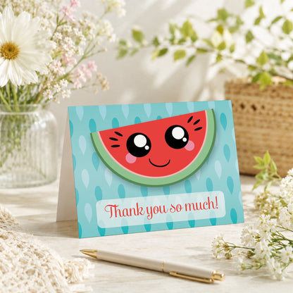 Smiling Watermelon Slice Thank You Card shown on a tabletop with a vase, spring and summer flowers, and a pen.