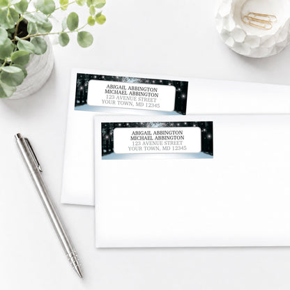 Address labels with winter scene design on a white surface with a pen and plant.