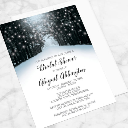 Bridal shower invitation with winter forest design, laid upon on a marble surface