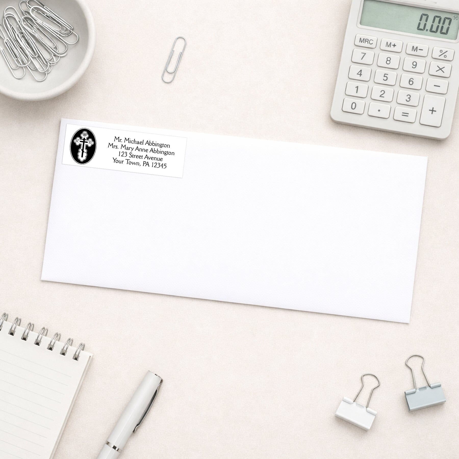 St. Olga Cross Orthodox Address Label shown on a white envelope with everyday office supplies