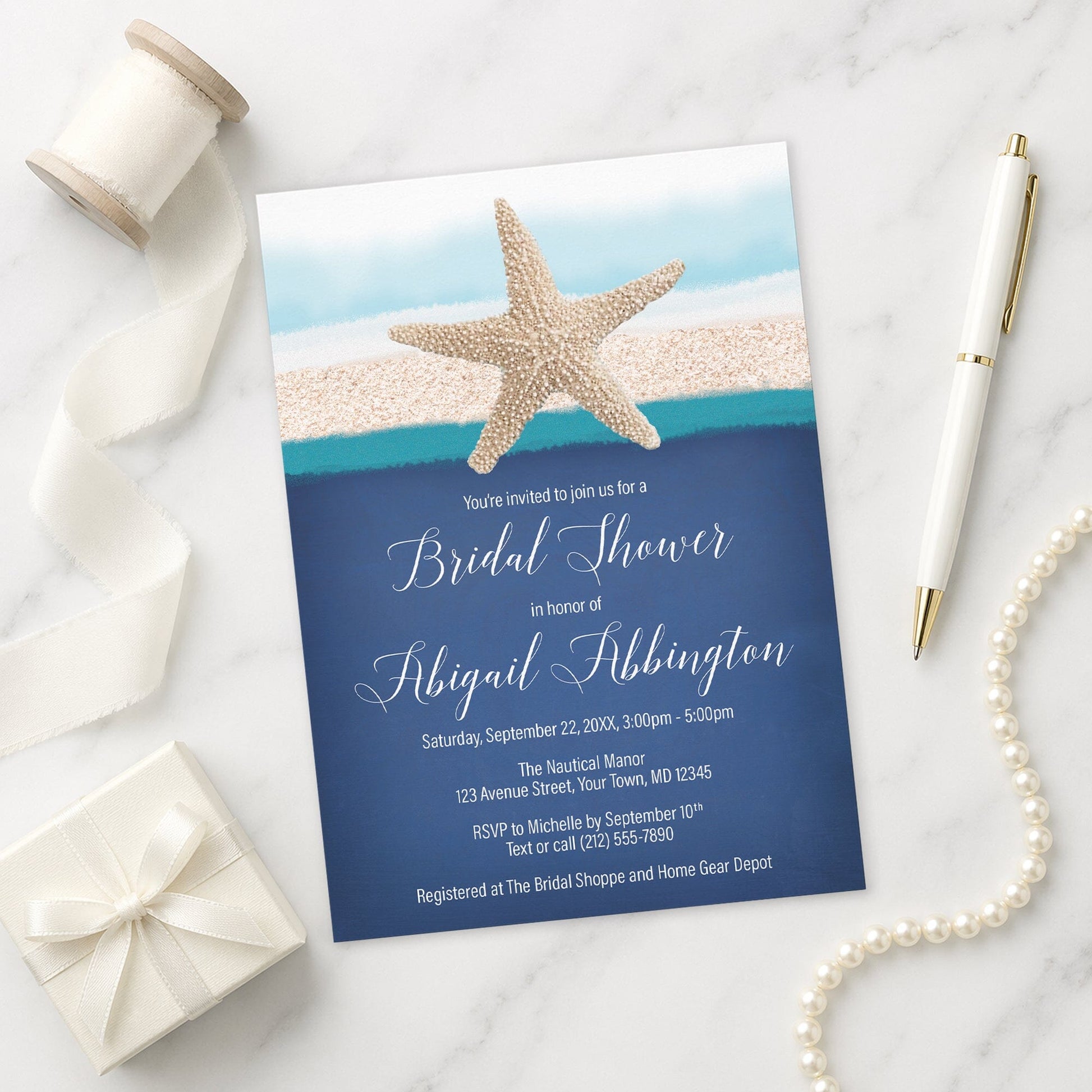Starfish Navy Blue Teal Beach Bridal Shower Invitation on a marble surface with gift, pen, and pearls.