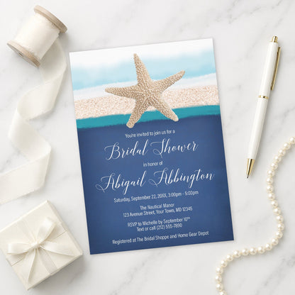 Starfish Navy Blue Teal Beach Bridal Shower Invitation on a marble surface with gift, pen, and pearls.