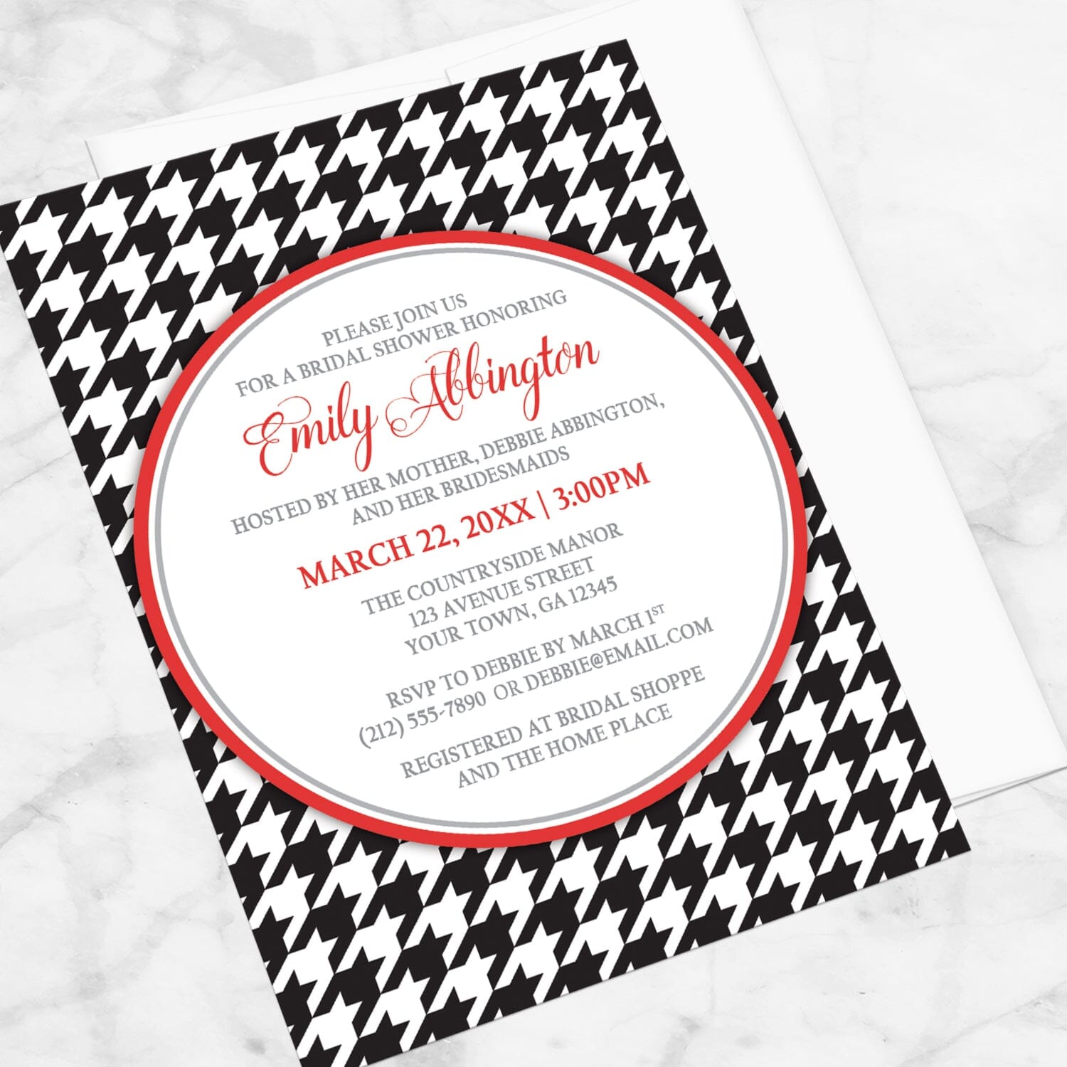 Stylish Black Houndstooth Red Bridal Shower Invitation shown at an angle on a marble surface with a white envelope.