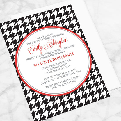 Stylish Black Houndstooth Red Bridal Shower Invitation shown at an angle on a marble surface with a white envelope.