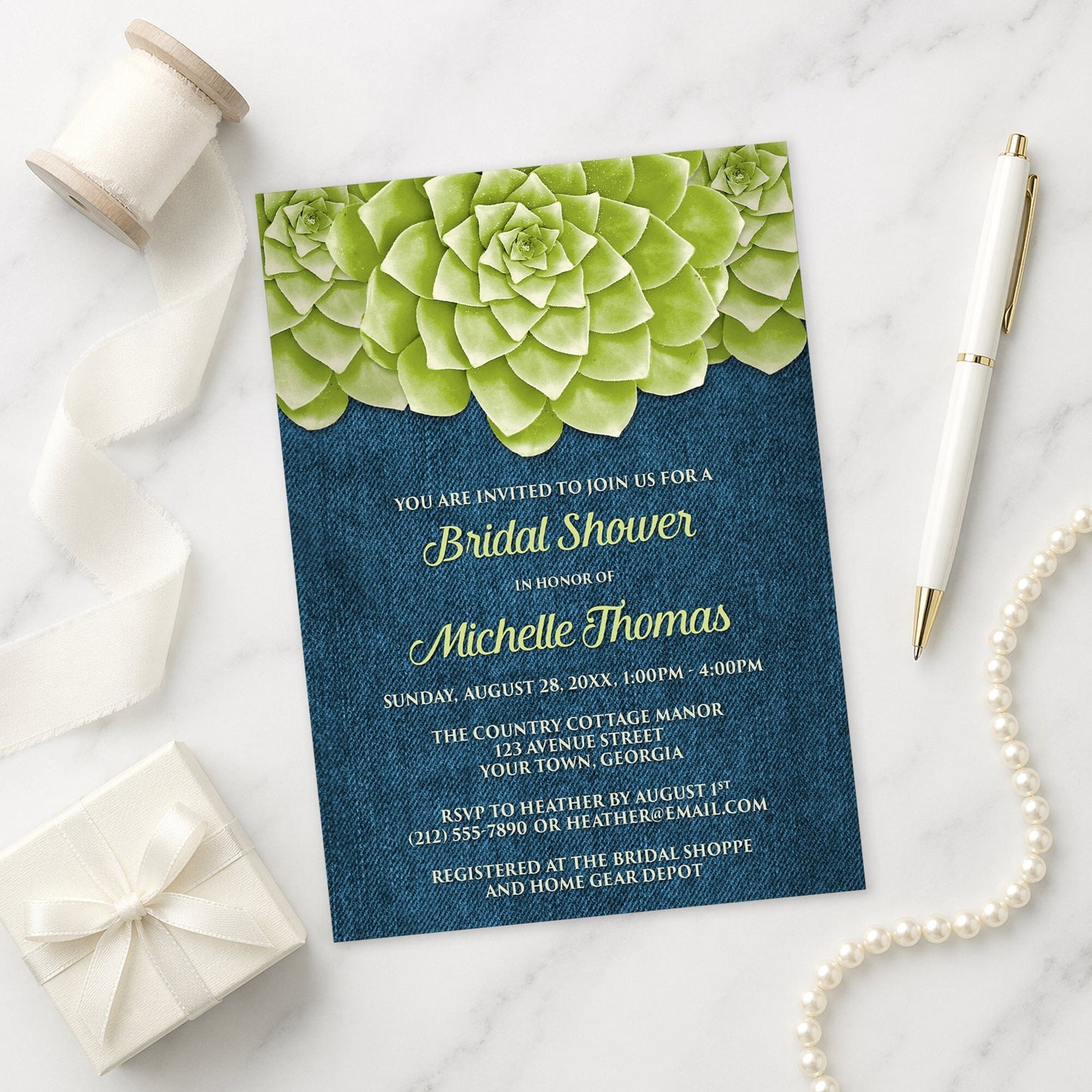 Succulent Green Blue Denim Bridal Shower Invitation shown on a marble surface with a white gift box, pen, ribbon, and pearls.