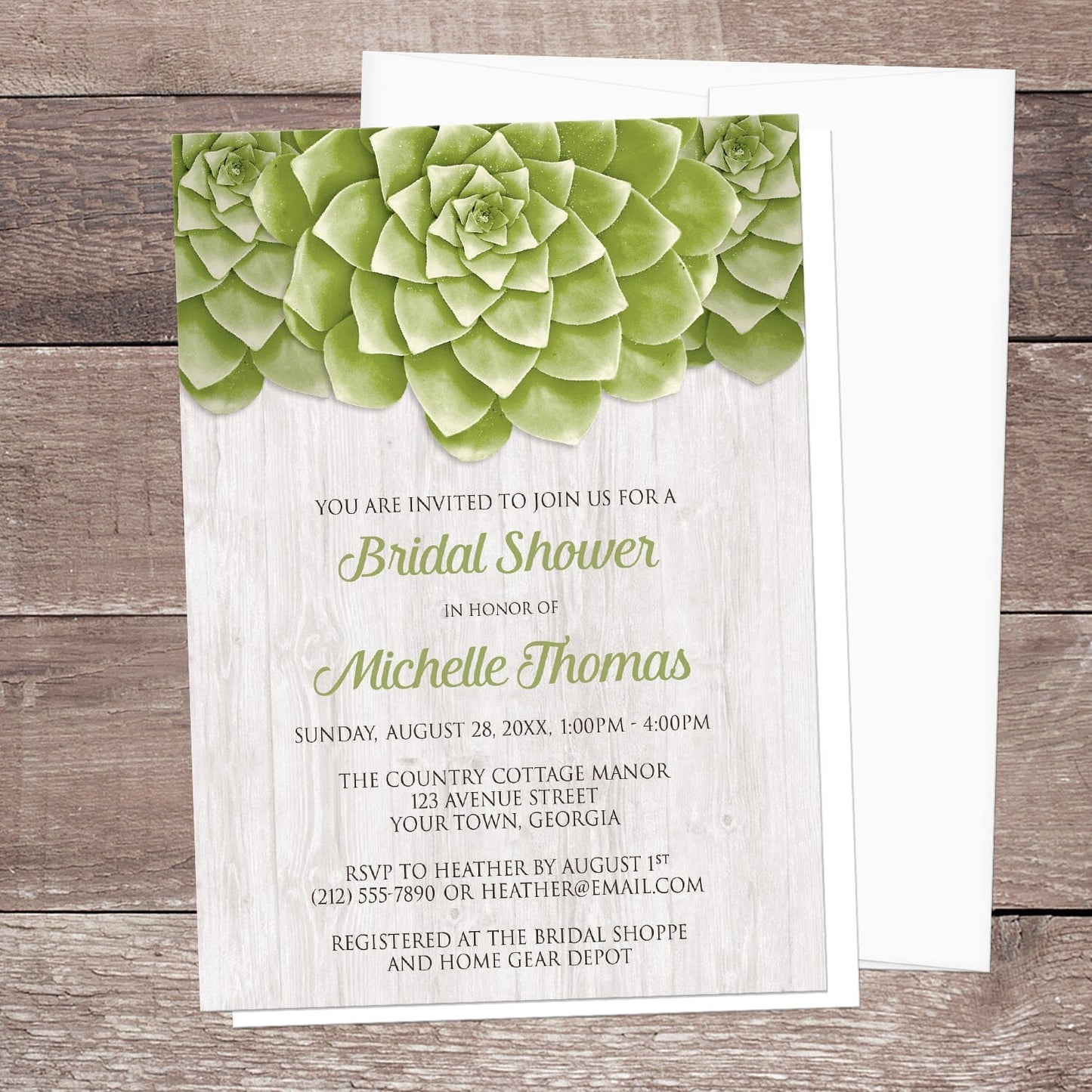 Bridal shower invitation with green succulent design shown on a wooden surface with a white envelope.