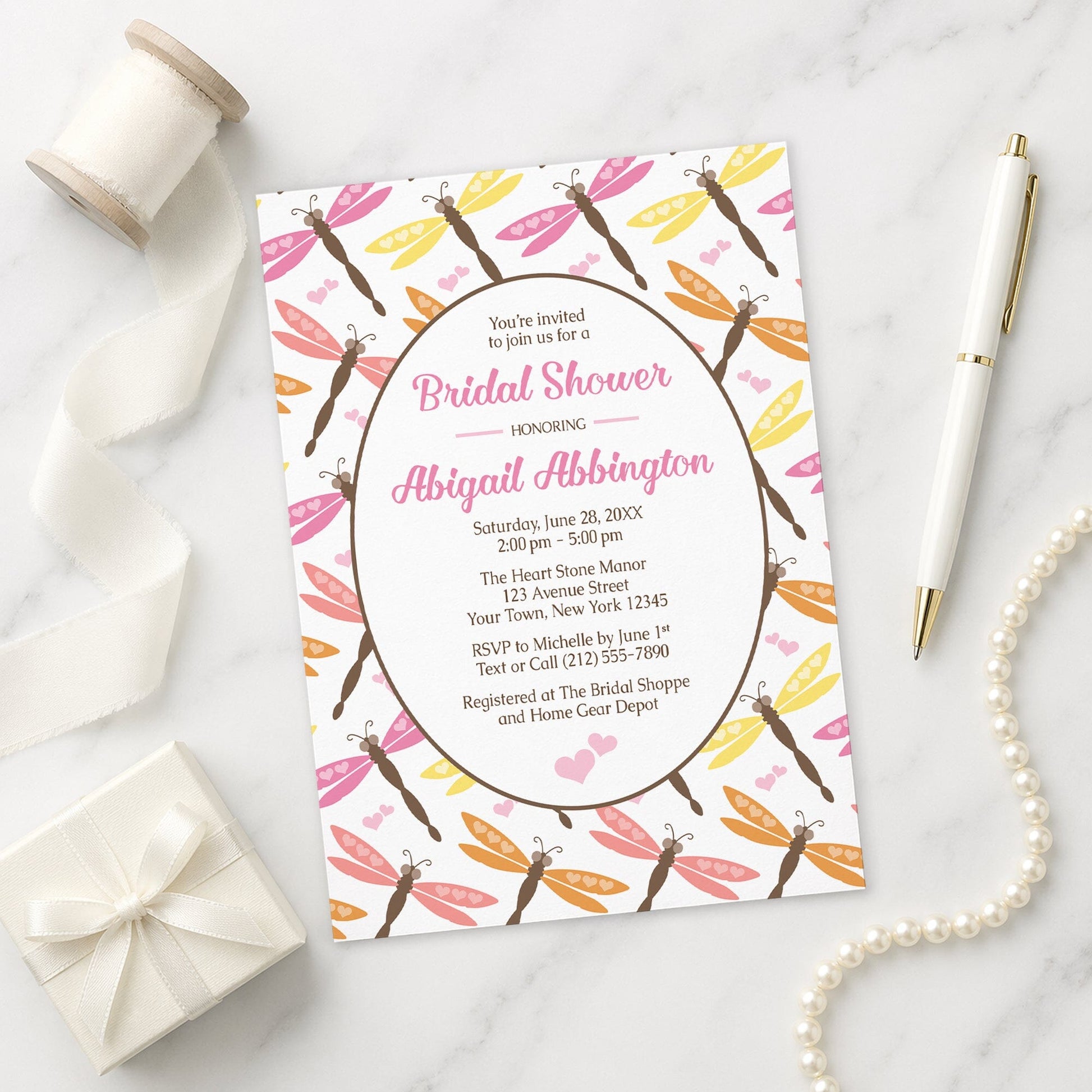 Summer Dragonfly Bridal Shower Invitation shown on a marble surface with a white gift box, pen, ribbon, and pearls.