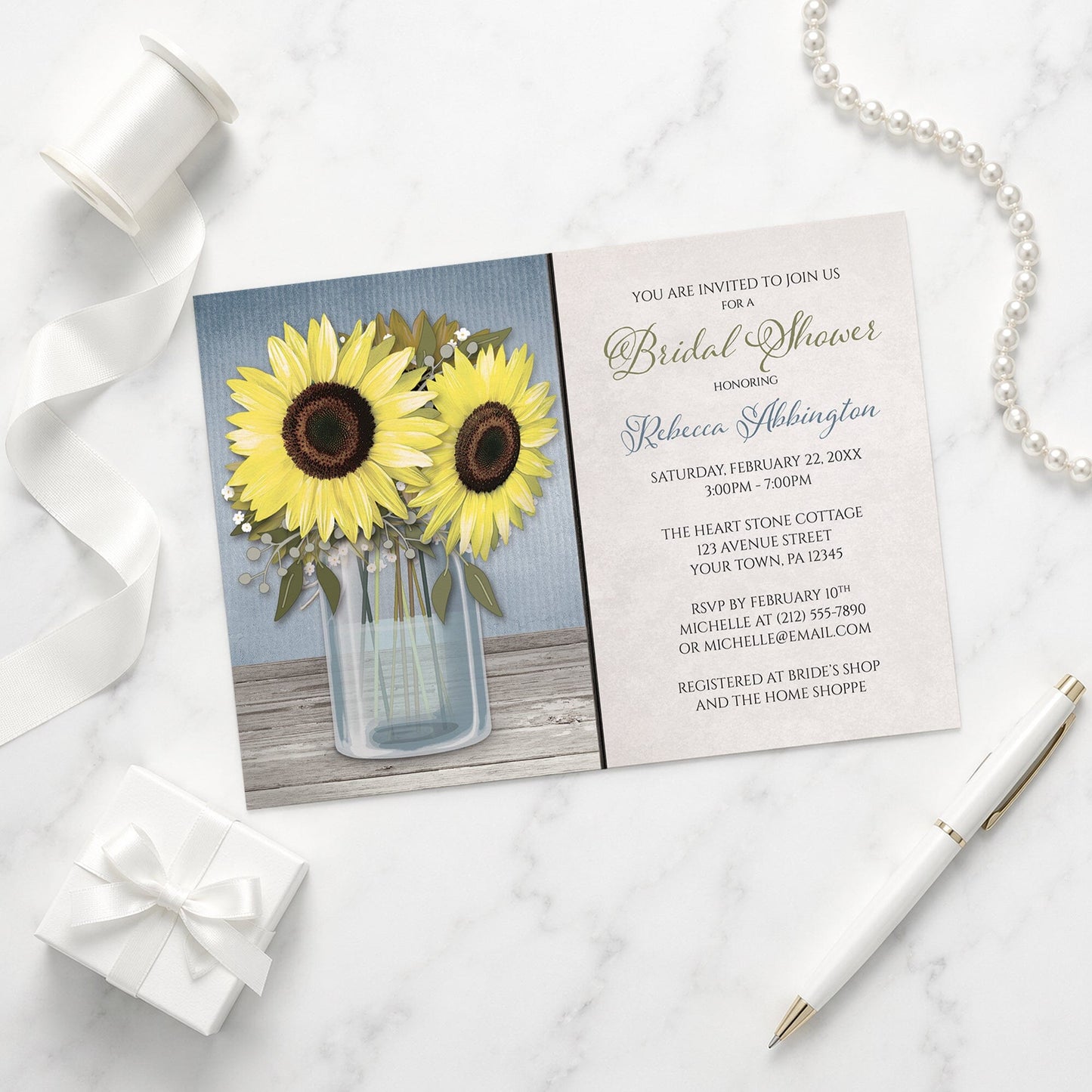 Sunflower Blue Mason Jar Rustic Bridal Shower Invitation shown on a marble surface with a white gift box, pen, ribbon, and pearls.
