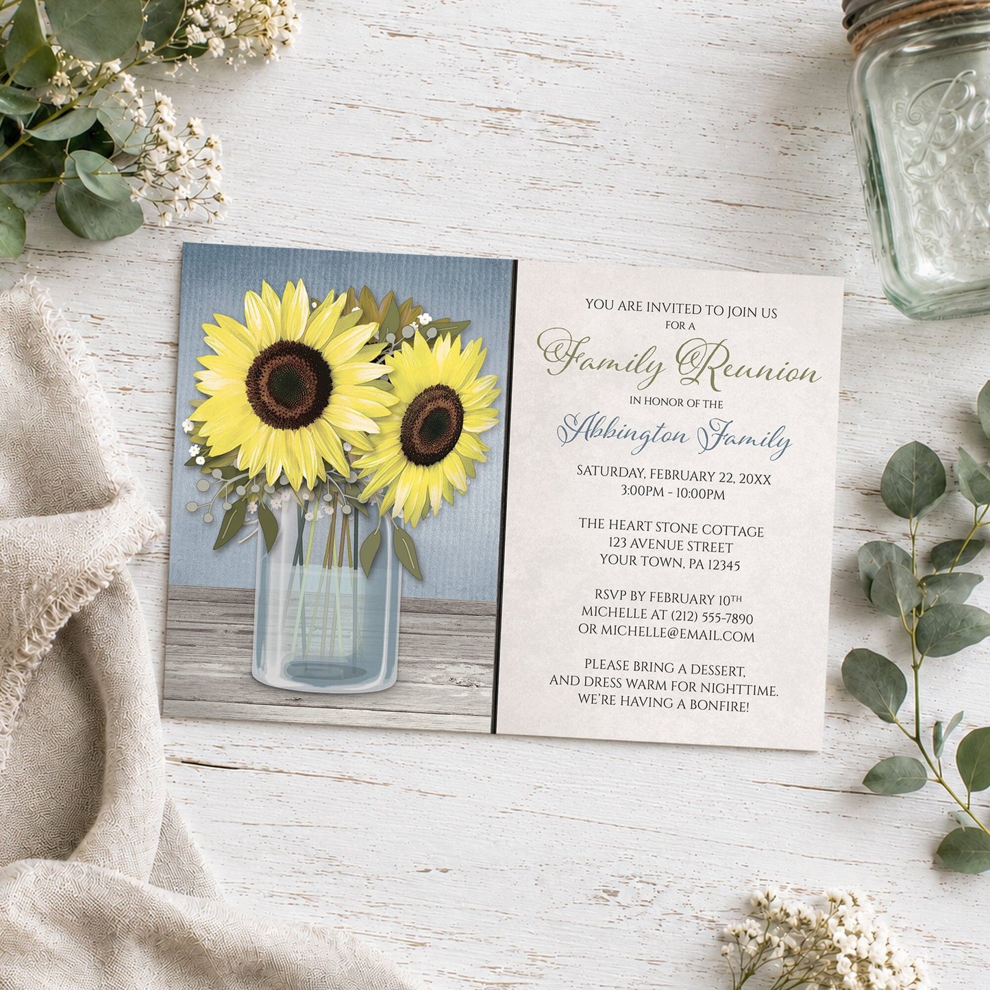 Sunflower Blue Mason Jar Rustic Family Reunion Invitation shown on a wooden surface with plants and a mason jar.