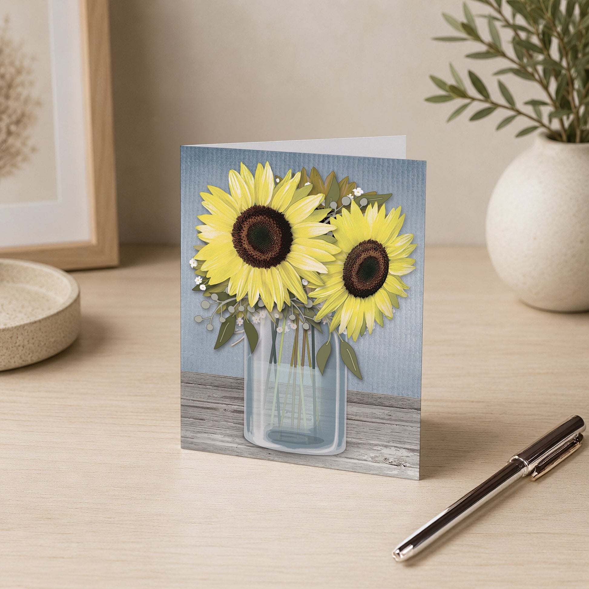 Sunflower Blue Mason Jar Rustic Note Card shown on a desk with a vase and a pen.