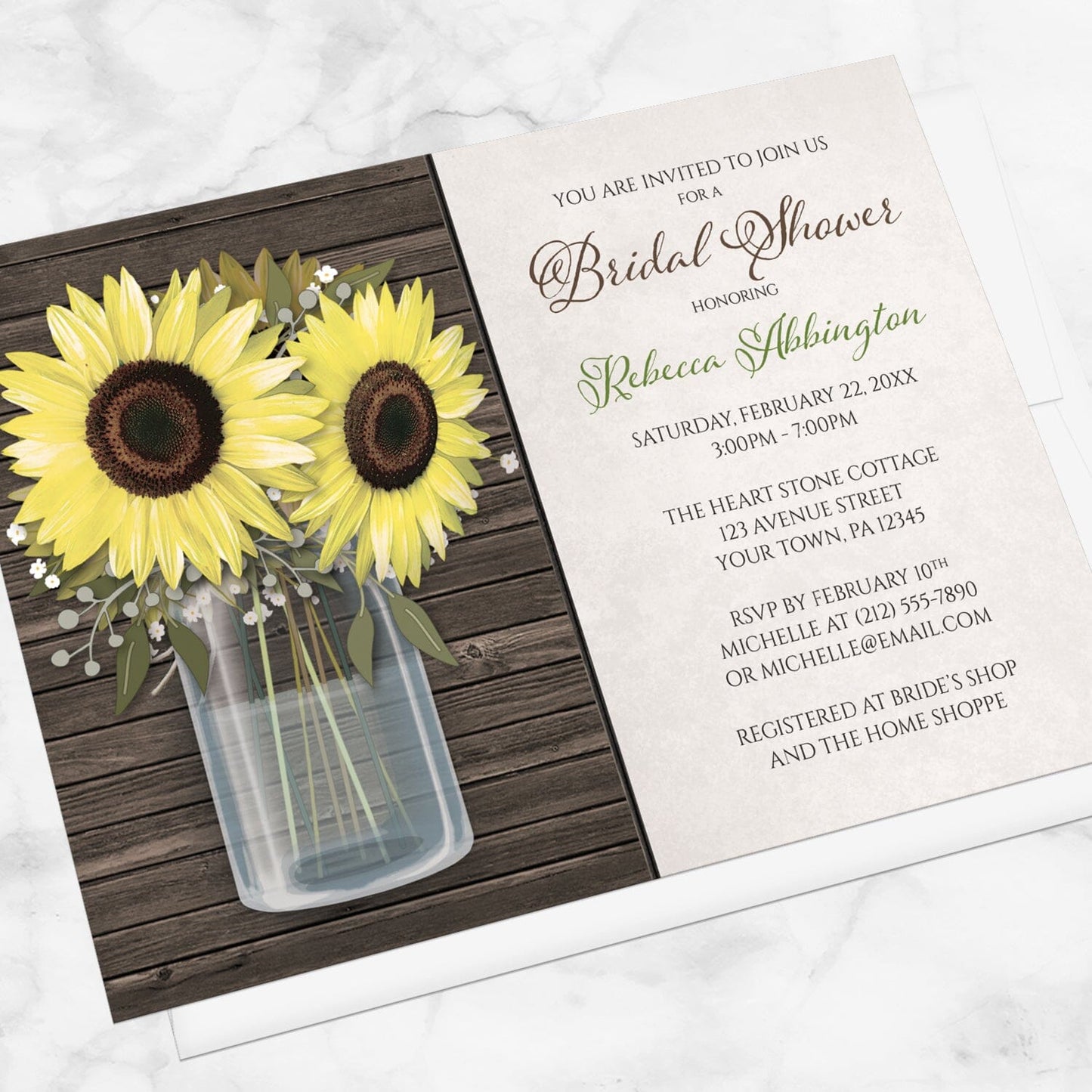 Sunflower Wood Mason Jar Rustic Bridal Shower Invitation shown at an angle on a marble surface with a white envelope.