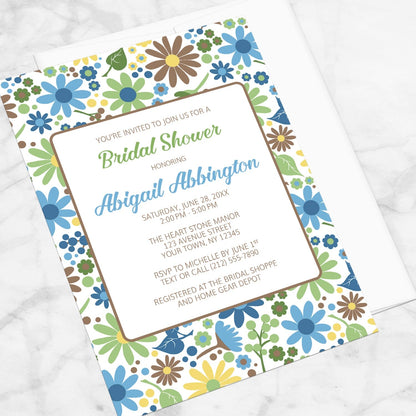 Sunny Summer Flowers Bridal Shower Invitation shown at an angle on a marble surface.