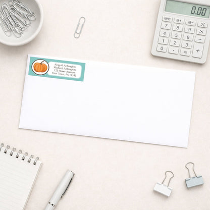 Teal Pumpkin Address Label shown on a white envelope with everyday office supplies