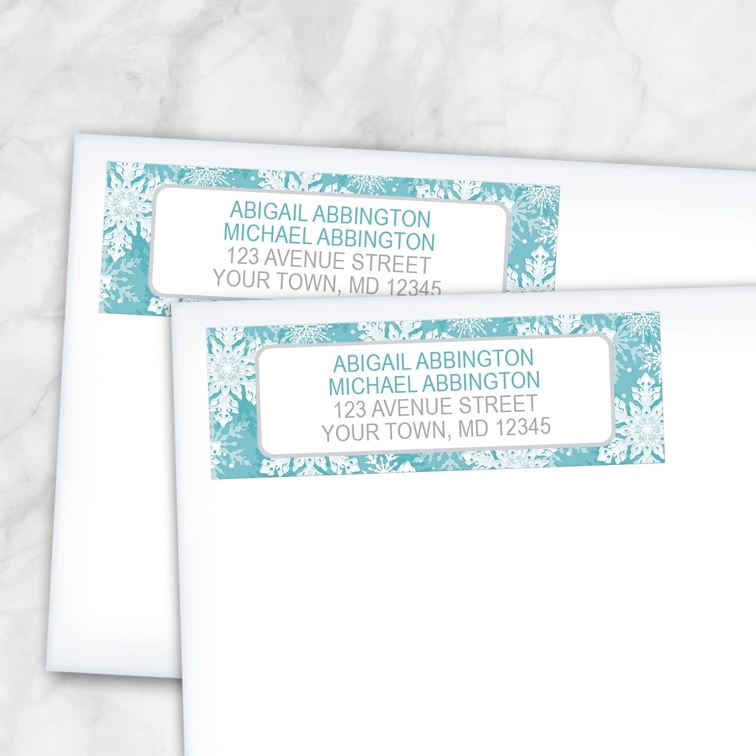 2 Teal Snowflake Winter Return Address Labels shown on white envelopes on a marble surface