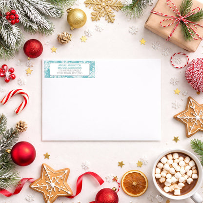 Teal Snowflake Winter Return Address Label shown on a white envelope with winter Christmas holiday supplies