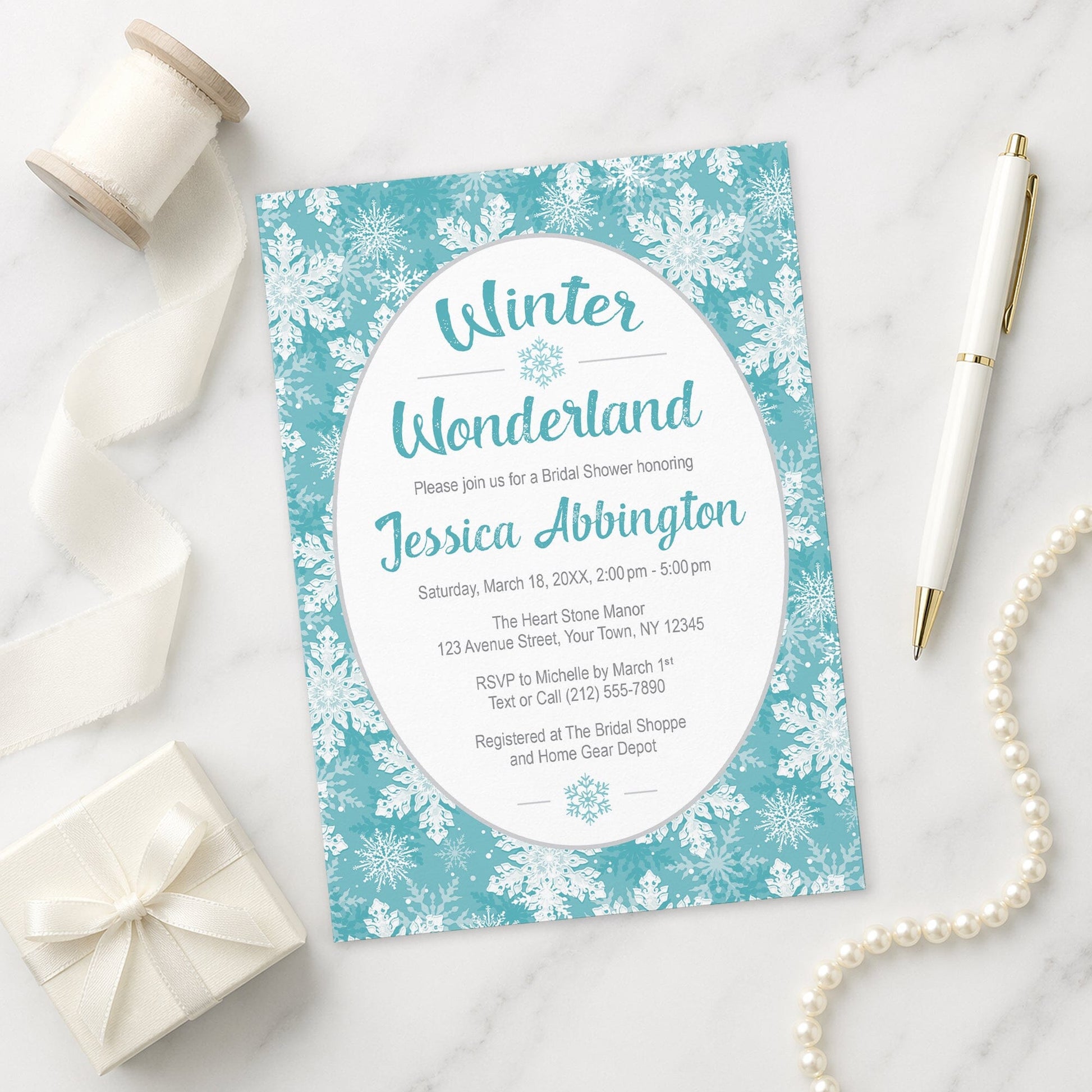 Teal Snowflake Winter Wonderland Bridal Shower Invitation shown on a marble surface with a white gift box, pen, ribbon, and pearls.