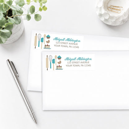 Turquoise Baking Address Labels shown on white envelopes, on a white surface with a plant and a pen.