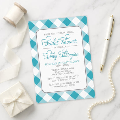 Turquoise Gingham Bridal Shower Invitation with a checkered border on a marble surface with ribbon and pen.
