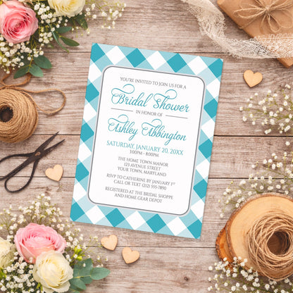 Turquoise Gingham Bridal Shower Invitation with a checkered border on a wooden surface with flowers and twine.