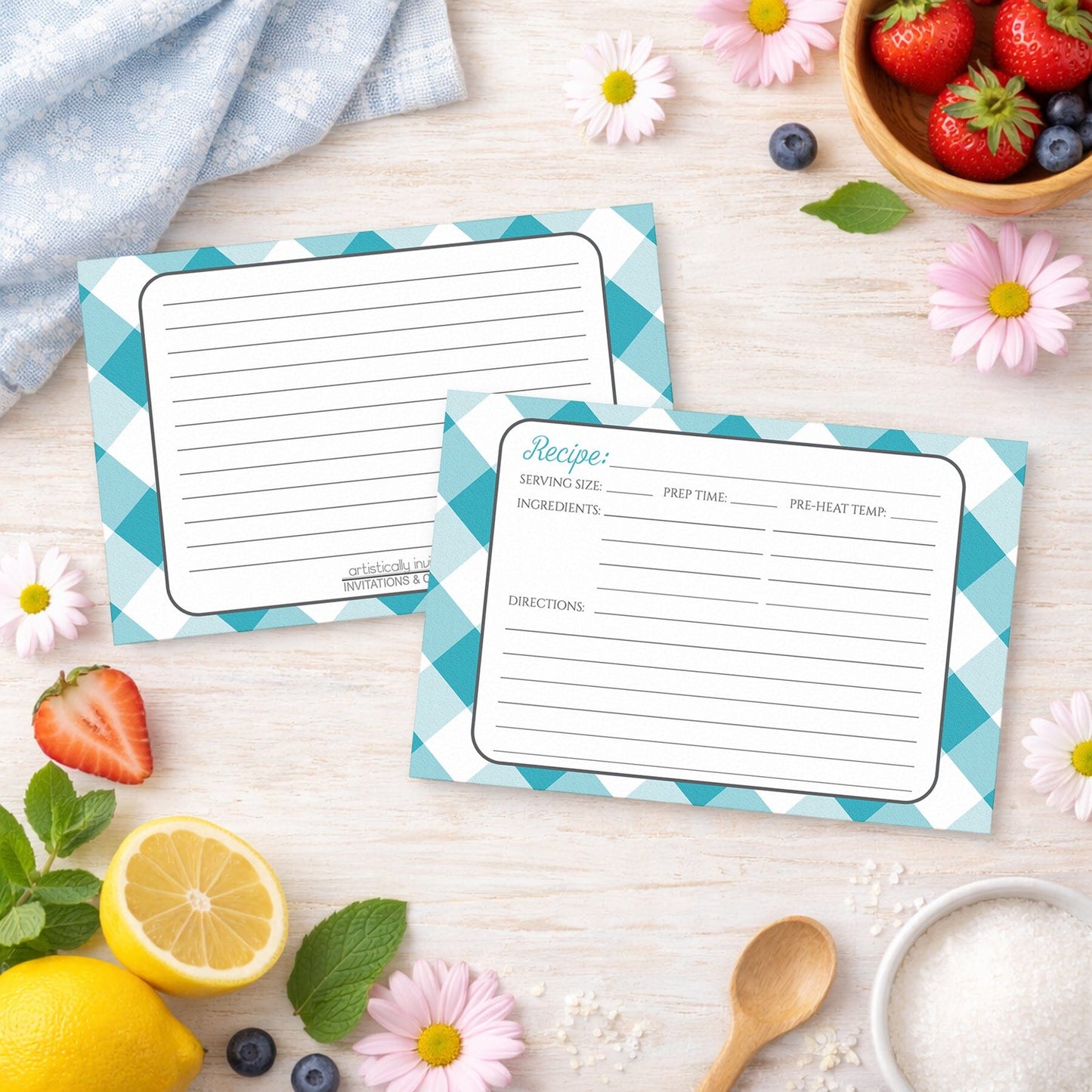 Two Turquoise Gingham Recipe Cards on a wooden surface with spring and summer fruits and flowers.