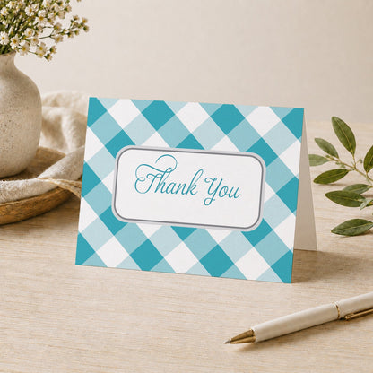 Turquoise Gingham Thank You Card shown on a desk with a vase, plants, and a pen.