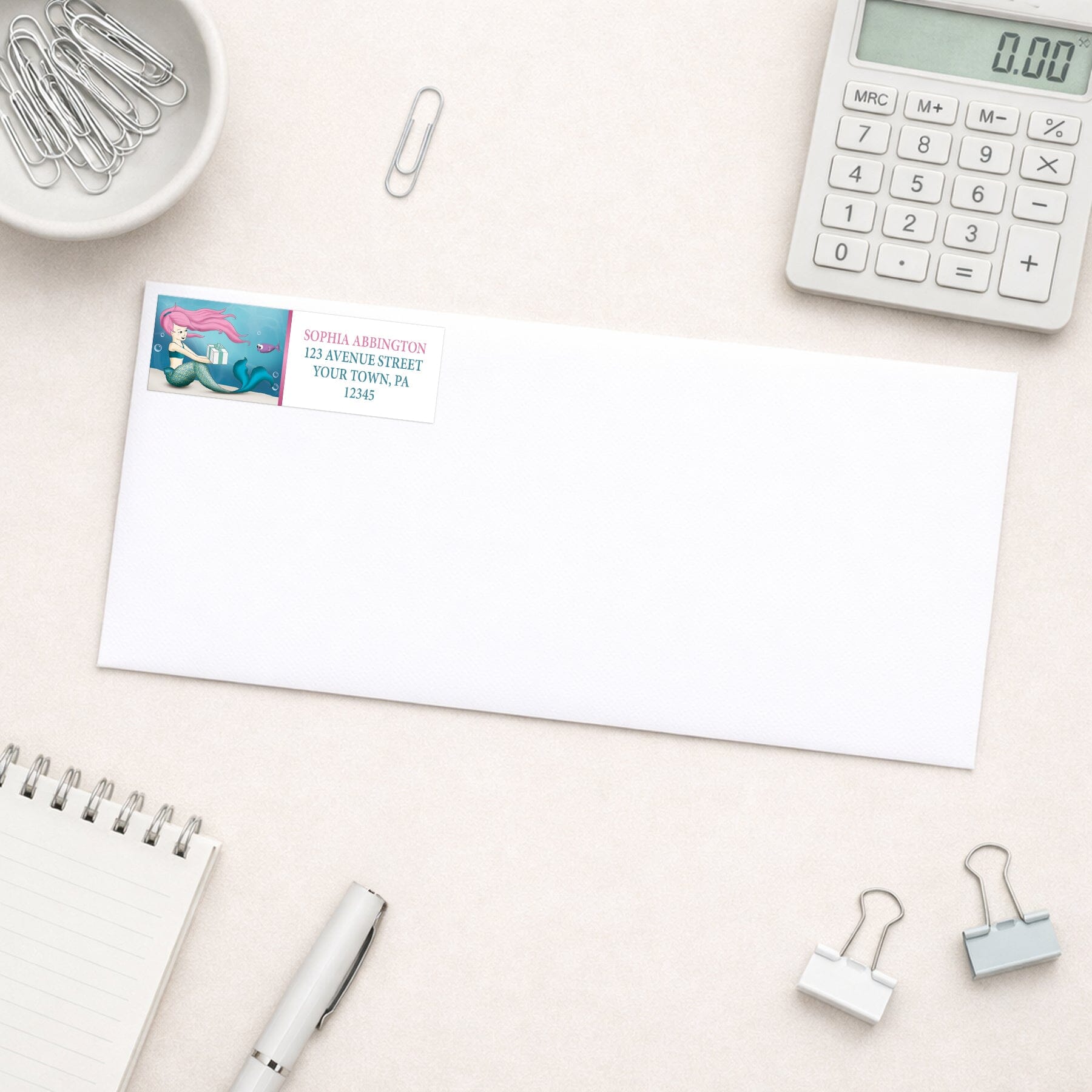 Under the Sea Mermaid Return Address Label shown on a white envelope with everyday office supplies