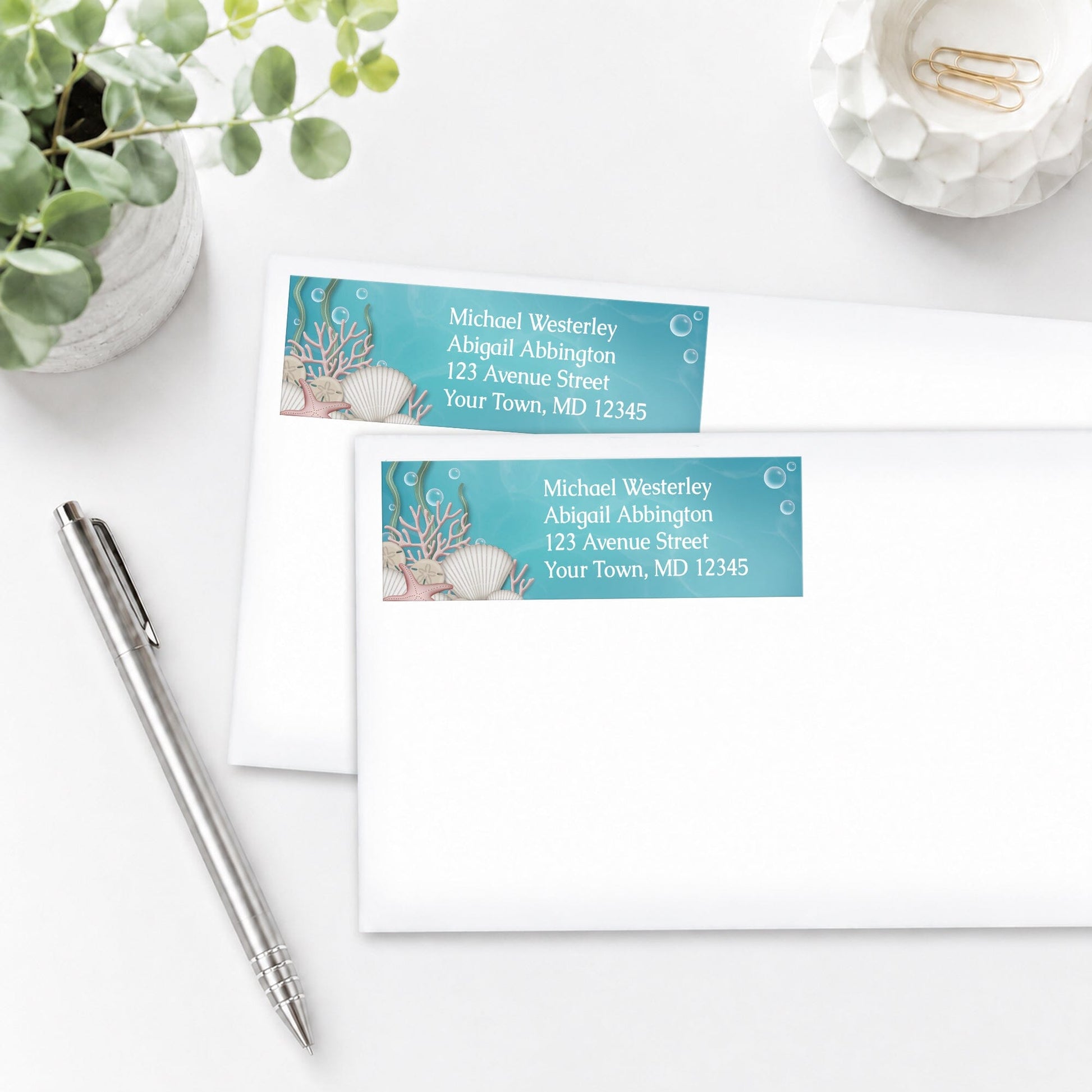 Whimsical Under the Sea Address Labels on white envelopes on a white surface with a pen and plant.