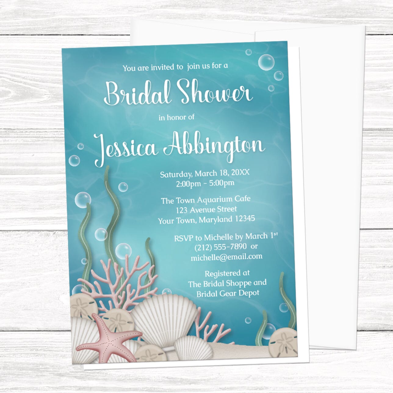 Bridal Shower invitation with an under the sea theme, featuring an underwater illustration, displayed with a white envelope on a white wood surface