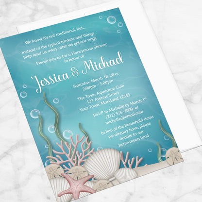 Whimsical Under the Sea Honeymoon Shower Invitation shown at an angle on a marble surface with a white envelope.