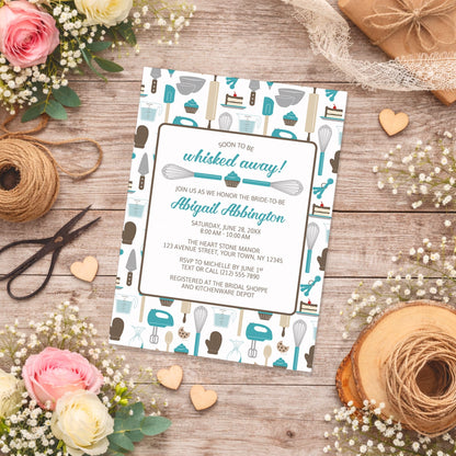 Whisked Away Turquoise Baking Bridal Shower Invitation with a kitchen tools and sweets theme, shown on a wooden surface with spring and summer flowers, small wood hearts, and twine.
