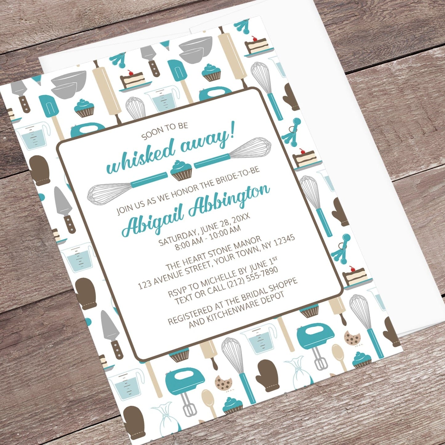 Whisked Away Turquoise Baking Bridal Shower Invitation with a kitchen tools and sweets theme, shown at an angle on a wooden surface with a white envelope.