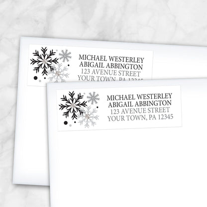 2 Winter Black Silver Snowflake Address Labels shown on white envelopes on a marble surface